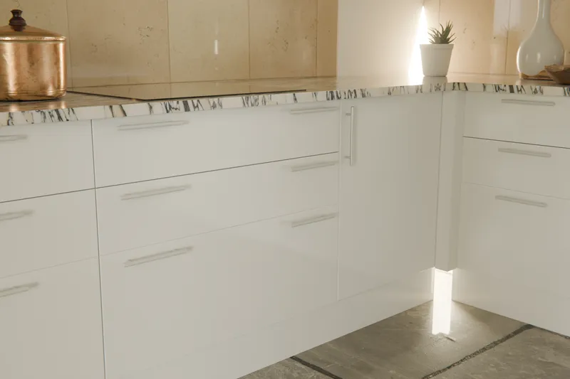 Gloss white drawer fronts with long stainless T-bar handles