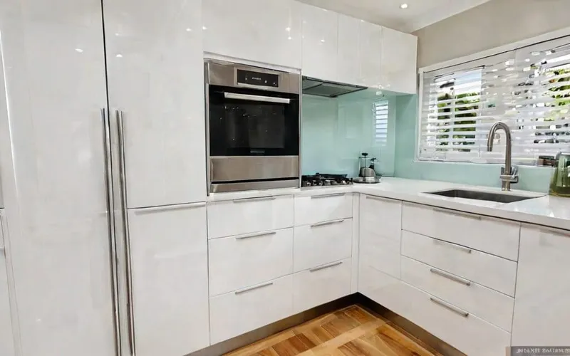 modern galley kitchen with white gloss cabinets and T-bar handles