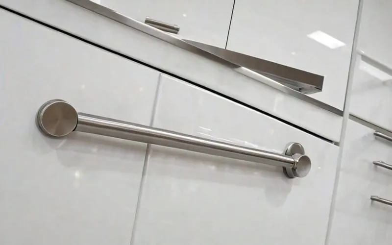 close-up of T-bar handle on gloss white cabinet door