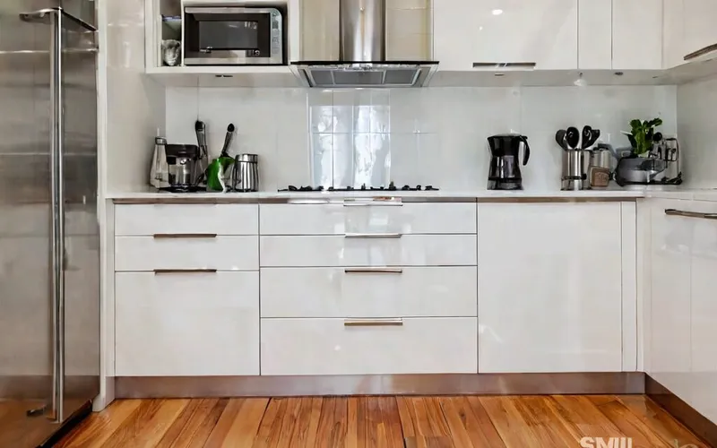 kitchen with white gloss cabinets, T-bar handles and soft-close drawers