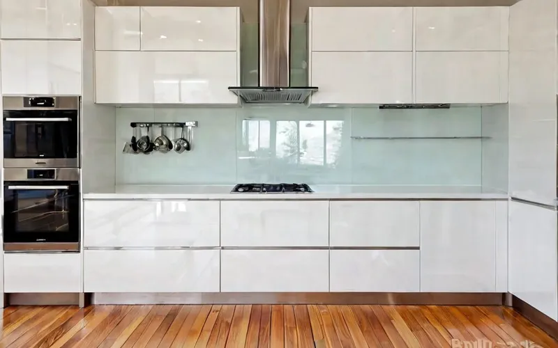 modern galley kitchen with white gloss cabinets and T-bar handles