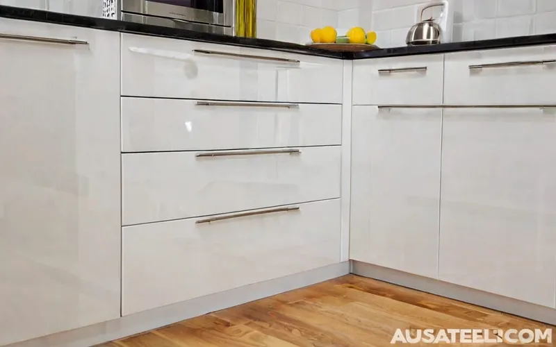 close-up of gloss white cabinet with T-bar handle and soft-close drawer