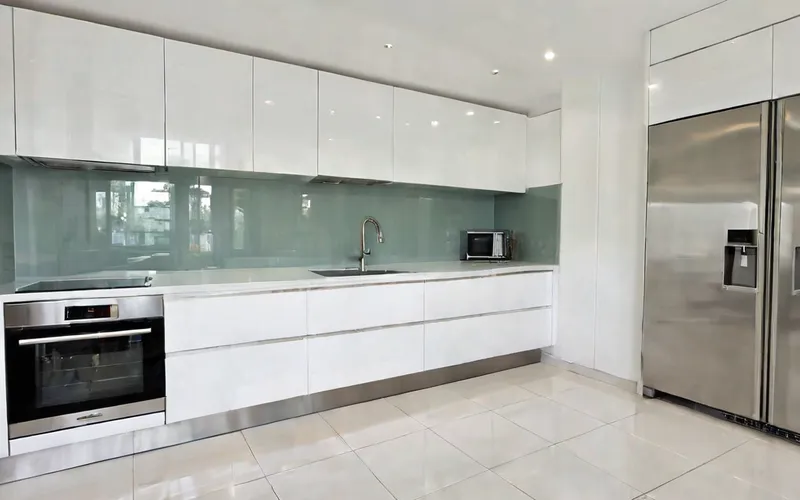 modern galley kitchen with white gloss cabinets and T-bar handles