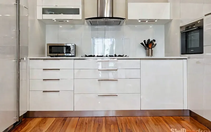 modern kitchen with white gloss cabinets, T-bar handles, and soft-close drawers