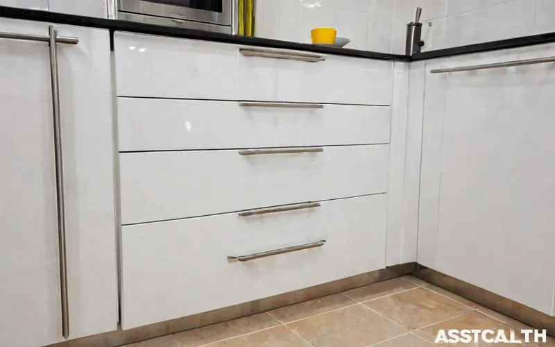 close-up of T-bar handle and gloss white door on a base cabinet