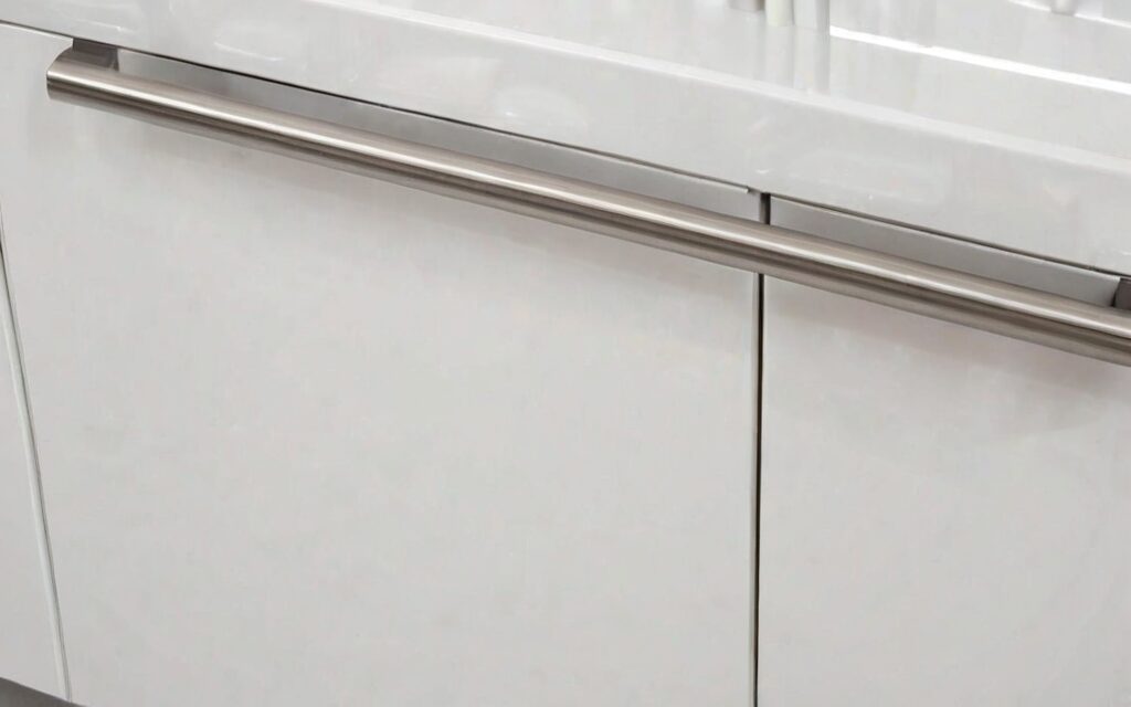 close-up of T-bar handle on white gloss cabinet door