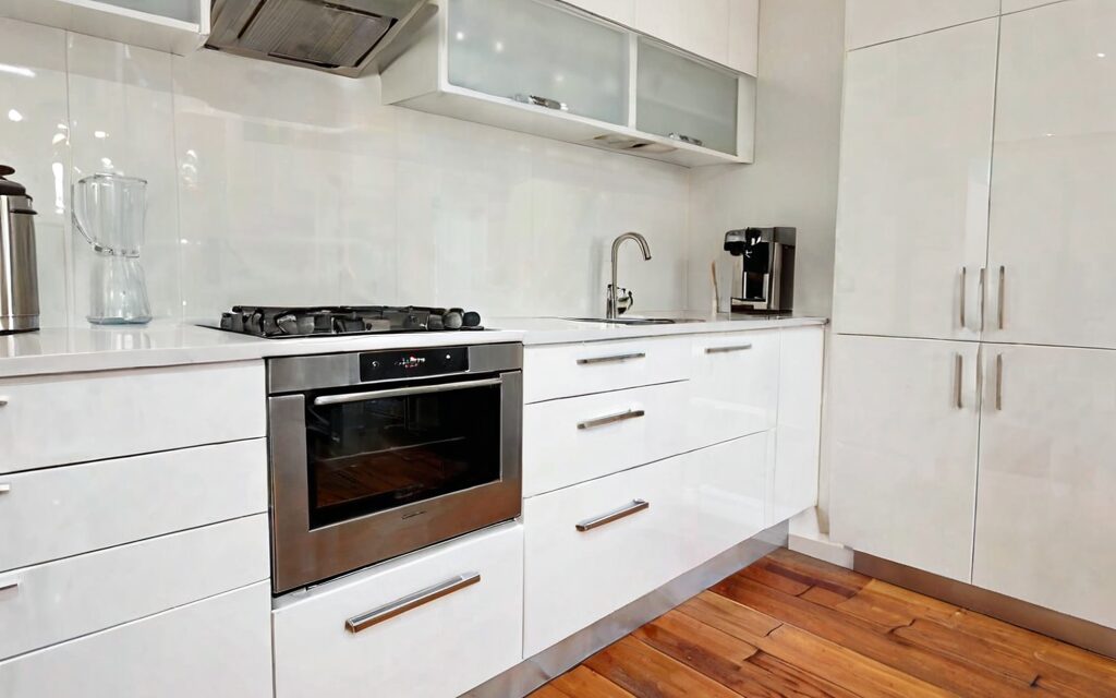 modern galley kitchen with white gloss cabinets and T-bar handles