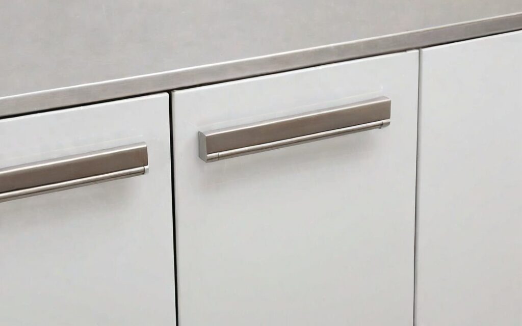 close-up of T-bar handle and gloss white door with soft-close drawer